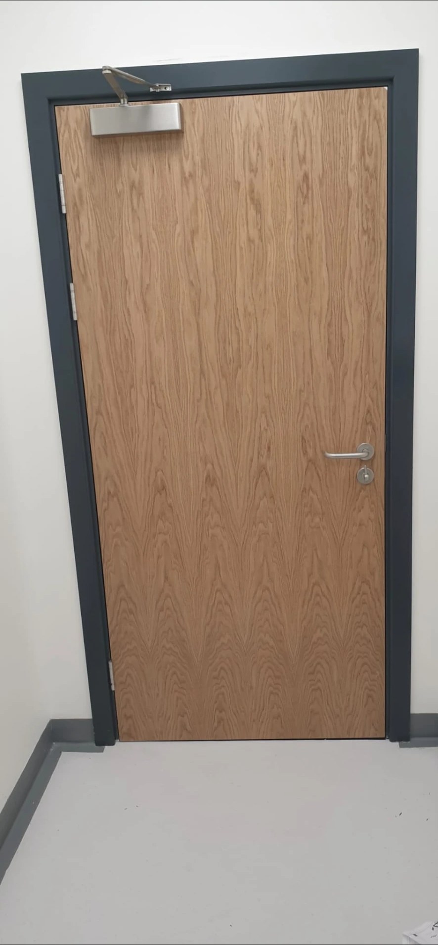 Commercial oak fire door with overhead door closer and ironmongery