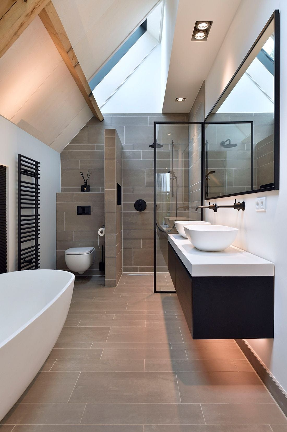 Loft bathroom with timber beams, skylight and floating vanity