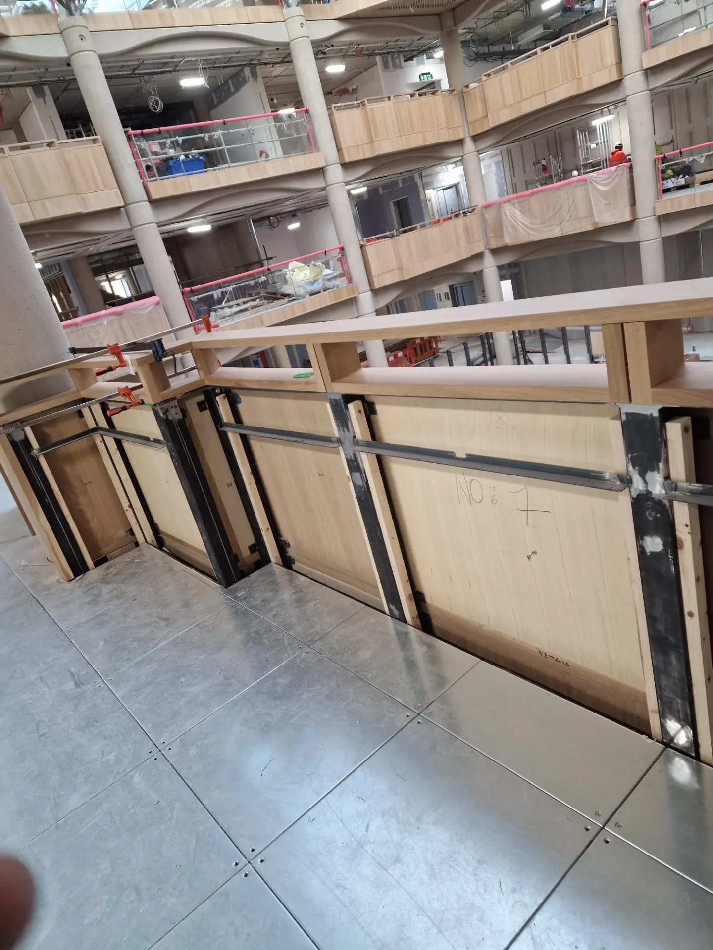 Oak reception joinery being assembled on site in a large atrium